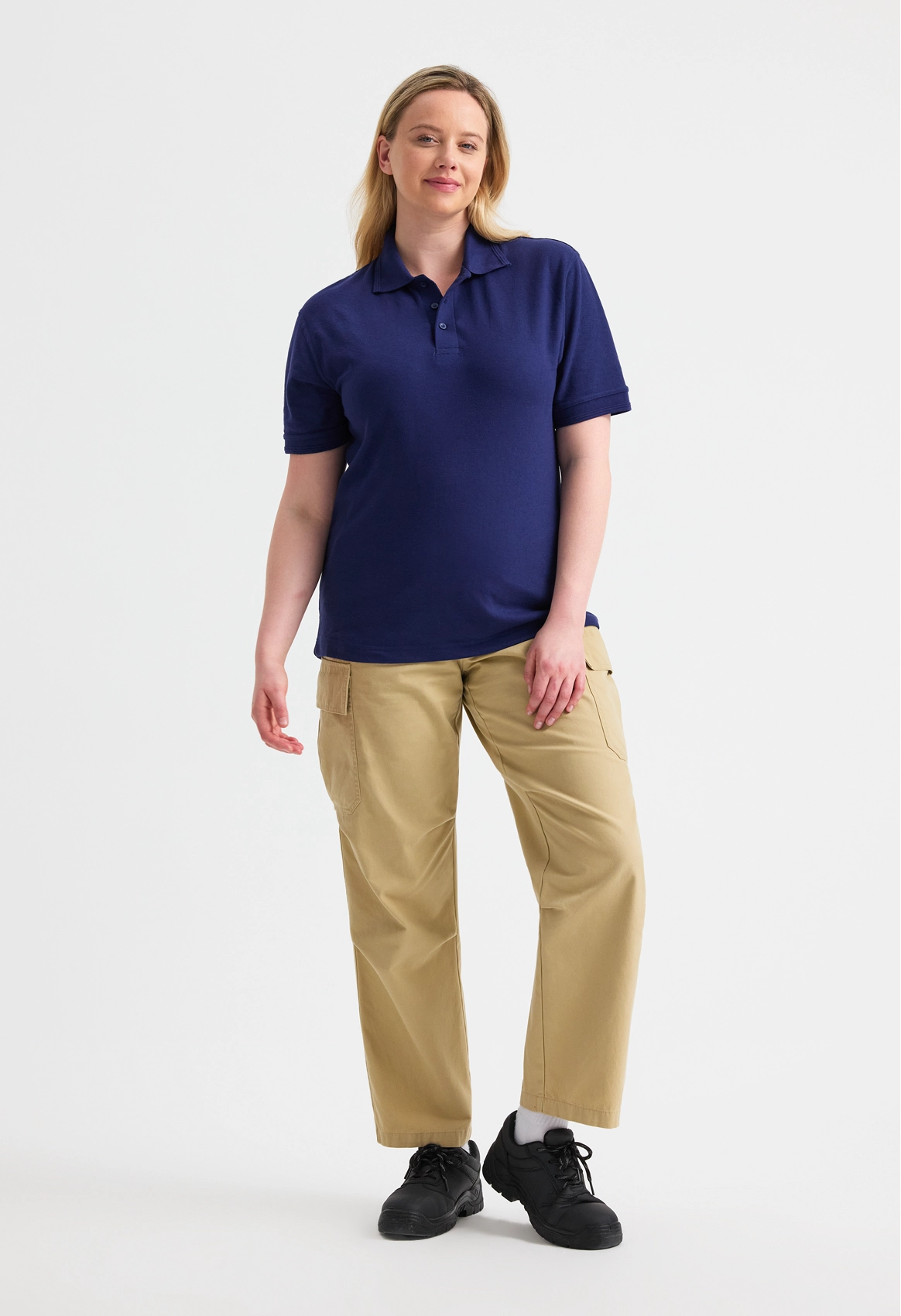 Person wearing a navy polo shirt and beige pants on a white background
